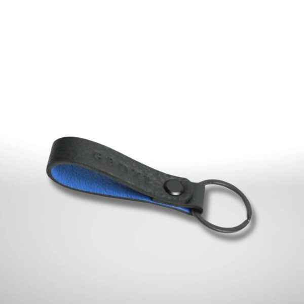 Schlüsselanhänger aus schwarzem Leder mit blauem Innenleder von GEOTI, minimalistisch inszeniert